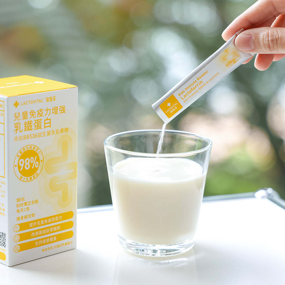Pouring a Lactovital Lactoferrin Kids immune booster sachet supplement into a glass of milk with packaging