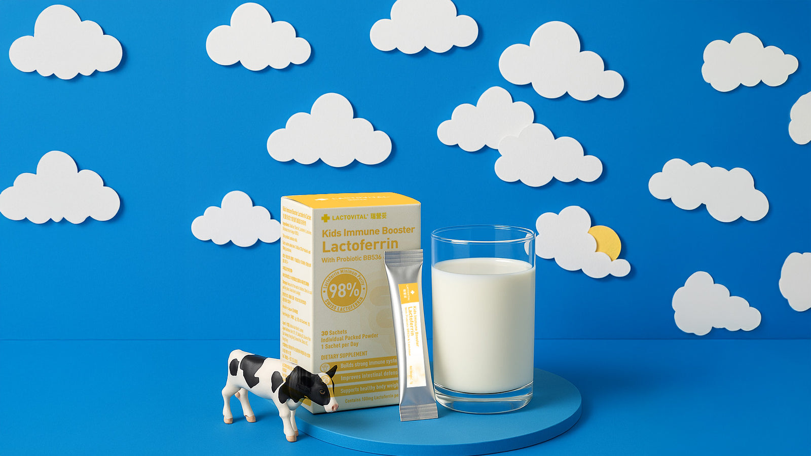 Lactovital Kids Immune booster formula with a glass of milk and cow toy figures